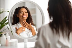 Beautiful Black Woman Looking At Mirror And Touching Soft Skin On Neck