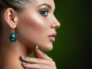 Back view of girl with green shiny makeup and manicure.