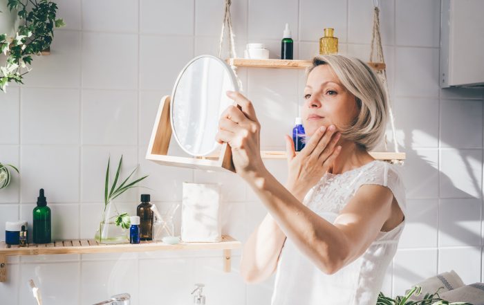 Beautiful middle aged woman taking care of her face