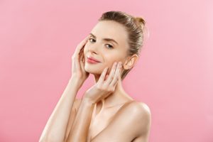 Beauty skin Concept Beautiful Young Caucasian Woman with Clean Fresh Skin look away with pink studio background. Girl beauty face care. Facial treatment. Cosmetology , beauty and spa.