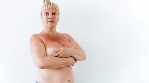 Chubby middle aged woman covering big breasts