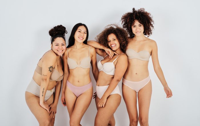 Group of happy multiethnic body positive ladies smiling at camera