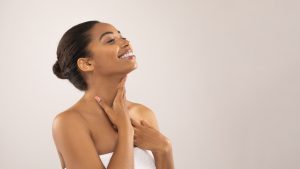 Hot cheerful young black woman massaging her neck, copy space