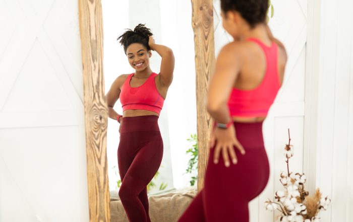 Joyful Black Lady After Weight Loss Posing Near Mirror Indoors