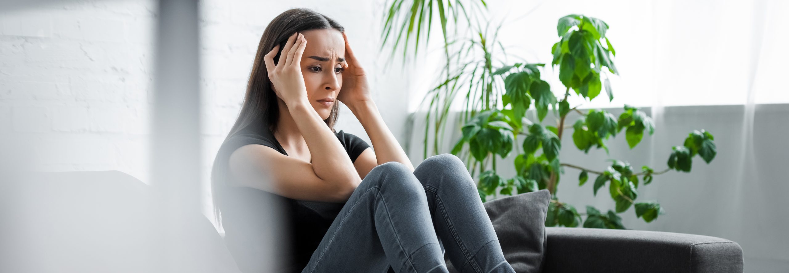 panoramic shot of upset young woman suffering from depression at home