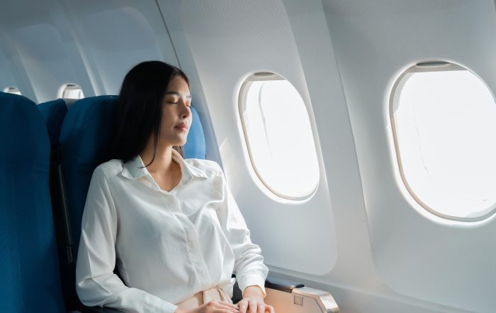 A female passenger traveling by plane sleeping on cushion airplane