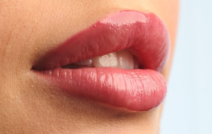 Closeup shot stylist applies lipstick to the lips of the female