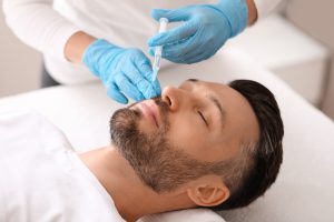 Attractive caucasian man visiting aesthetic clinic, getting lips filler