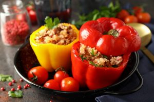 Concept of tasty food with stuffed pepper on dark textured backg