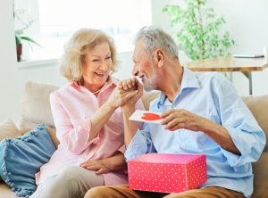 gift woman man couple happy love happiness present kiss romantic smiling together box wife husband elderly old senior mature retired